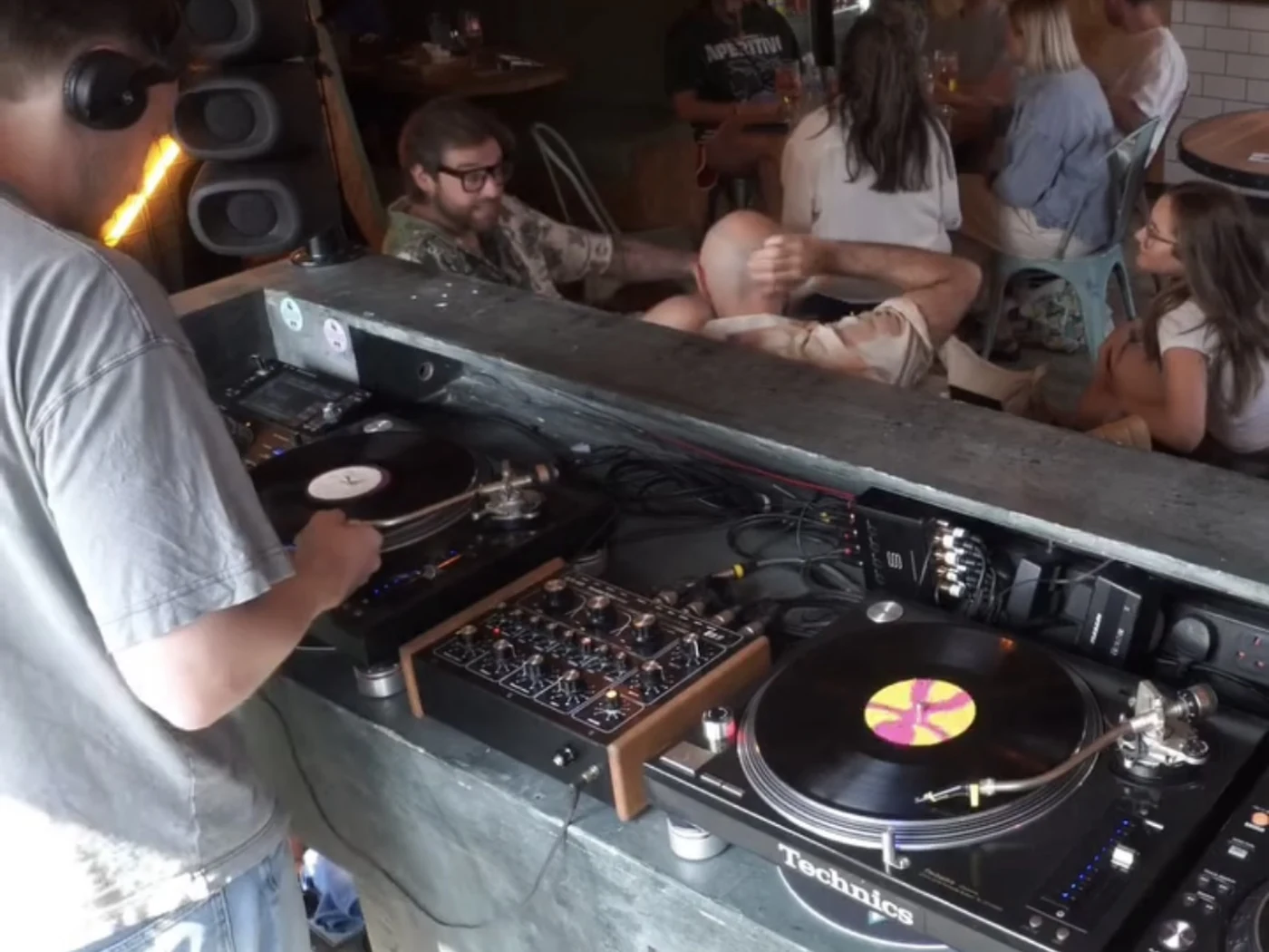 A CAFE HAUS vinyl DJ set with people chatting and listening in an intimate room