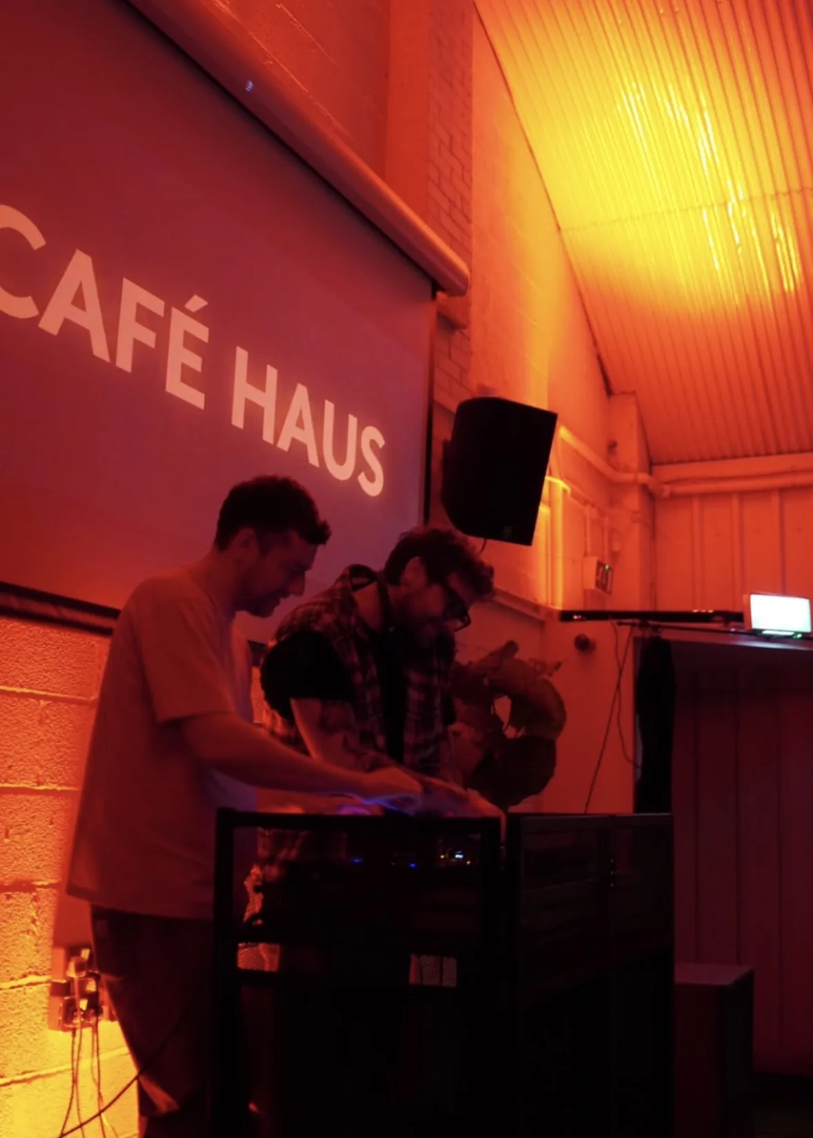 Cafe Haus DJ performance under warm red lighting