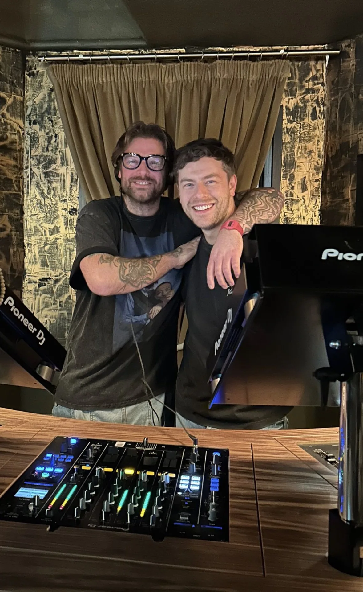 Two Cafe Haus DJs together behind the booth