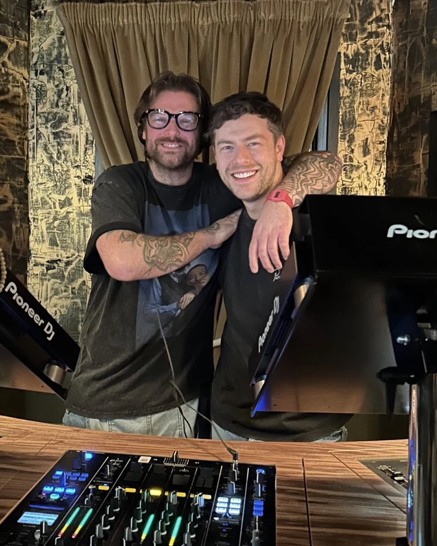 CAFE HAUS DJs smiling together behind their DJ setup